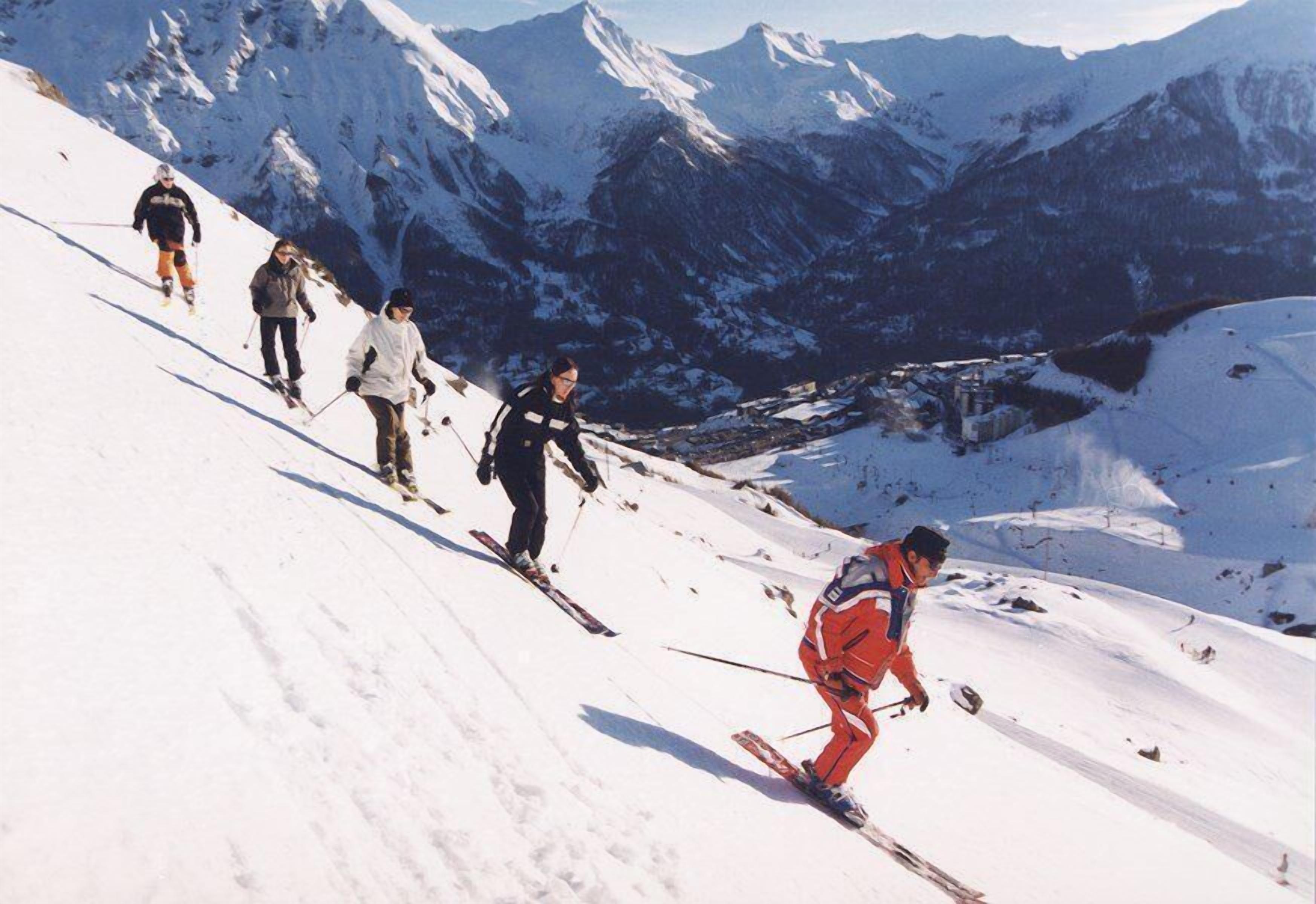 Un groupe de skieurs dévalant une pente enneigée.