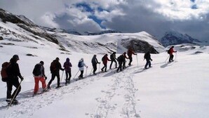 Eine Gruppe Wanderer auf einem verschneiten Bergpfad.