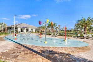 A pool area with water jets, palm trees, and lounge chairs. - Great Location! Disney-Universal-Kid Gear-Free Pool Heat-Lake view- Family Fun (Kissimmee)
