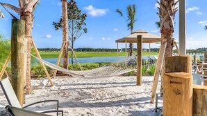 A beach with hammocks, a wooden structure, and a view of a lake. - Great Location! Disney-Universal-Kid Gear-Free Pool Heat-Lake view- Family Fun (Kissimmee)