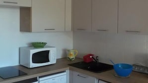A kitchen with white cabinets, a microwave, a sink, and a blue bowl. - 50m from ski slopes, 3rd floor, tv, 25m², Orcières Merlette 1850 (Orcières)