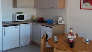 A compact kitchen with a microwave, coffee maker, and a table with a mug and a striped cup. - 50m from ski slopes, 3rd floor, tv, 25m², Orcières Merlette 1850 (Orcières)