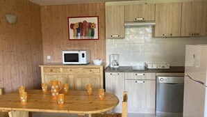A compact kitchen with wooden cabinets, a microwave, a coffee maker, and a refrigerator. - 50m from ski slopes, 6th floor, tv, 45m², Orcières Merlette 1850 (Orcières)