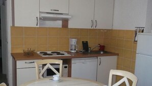 A compact kitchen with a stove, coffee maker, and a sink. There is a small dining table with two chairs. - 200m from resort center, 1st floor, tv, 40m², Orcières Merlette 1850 (Orcières)