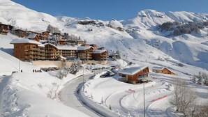 A snow-covered mountain resort with wooden buildings, a winding road, and ski slopes. - 50m from ski slopes, 7th floor, tv, 19m², Orcières Merlette 1850 (Orcières)