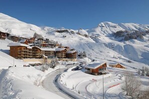 A snow-covered mountain resort with wooden buildings, a winding road, and ski slopes. - 50m from ski slopes, 3rd floor, tv, 40m², Orcières Merlette 1850 (Orcières)