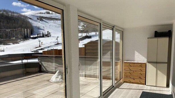 A modern room with large sliding glass doors leading to a balcony with a snowy mountain view. - 50m from ski slopes, 1st floor, terrace, tv, 40m², Orcières Merlette 1850 (Orcières)