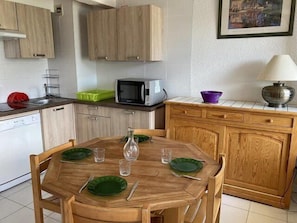 A compact kitchen with wooden cabinets, a microwave, and a dining area with a table set for two. - 200m from resort center, 3rd floor, tv, 55m², Orcières Merlette 1850 (Orcières)