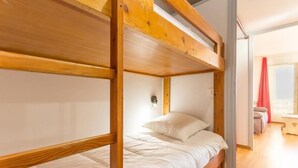 A bunk bed room with wooden frames and white bedding. - 3rd floor, balcony, tv, 22m², La Rosière (La Rosière Montvalezan)