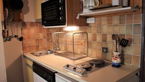 Une cuisine compacte équipée d’un lave-vaisselle, d’une cuisinière et d’une machine à café.