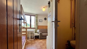 A hallway leading to a dining area with a table and chairs, a sofa, and a toilet. - 100m from ski slopes, 3rd floor, tv, 18m², Vars (Vars)