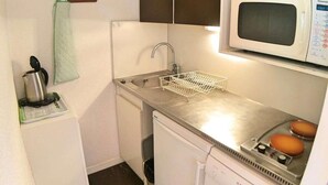A compact kitchen with a microwave, sink, and Bosch dishwasher.