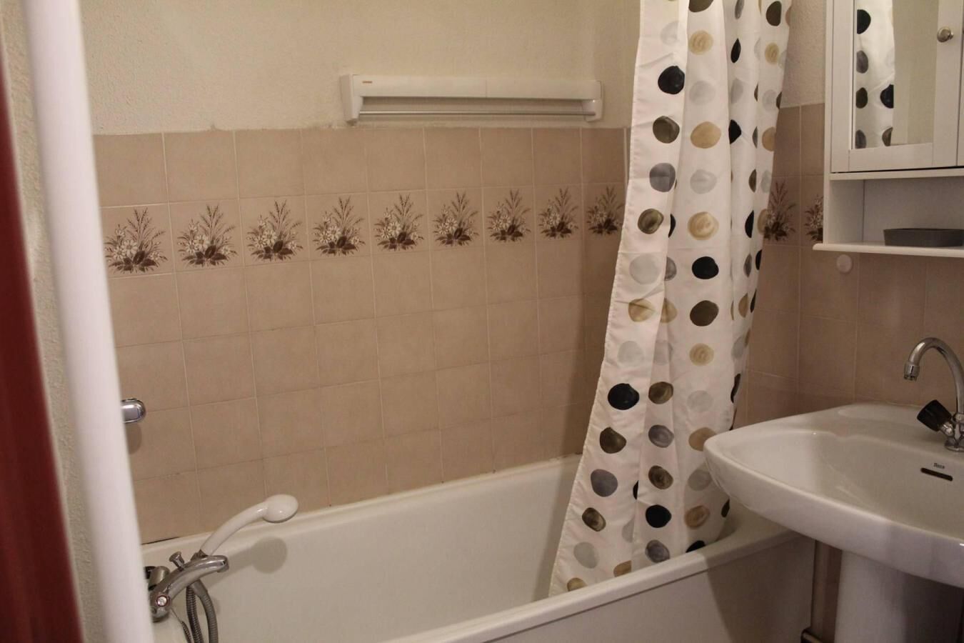 Een badkamer met een bad, een wastafel en een douchegordijn.