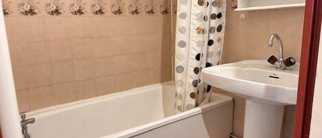 Un baño con bañera, lavamanos e inodoro.