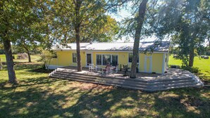A yellow house with a porch, surrounded by trees. - Rural Retreat with Private Pond, ATV Trails and Event Space (Buffalo)