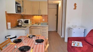 Cocina compacta con microondas, hervidor y mesa lista para comer.
