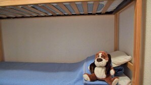 Una habitación pequeña con una cama individual, colchón azul y estructura de madera.