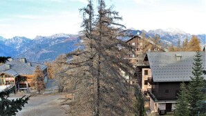 A mountain lodge with multiple buildings, a ski lift, and a view of snow-capped mountains. - 50m from ski slopes, 3rd floor, balcony, tv, ski locker, 24m², Risoul (Risoul)