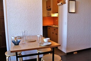 A dining area with a wooden table set for four, including bowls, glasses, and plates.