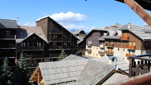 Un ensemble de bâtiments en bois dotés de balcons, qui font probablement partie d’un complexe touristique de montagne.