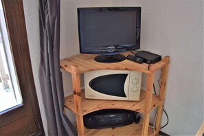A wooden TV stand with a Samsung TV, a microwave, and a DVD player. - 100m from resort center, 5th floor, balcony, tv, ski locker, 23m², Risoul (Risoul)