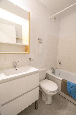 A bathroom with a white sink, toilet, and bathtub.