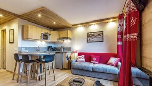 Een functionele ruimte met een kitchenette, een eethoek en een bank.