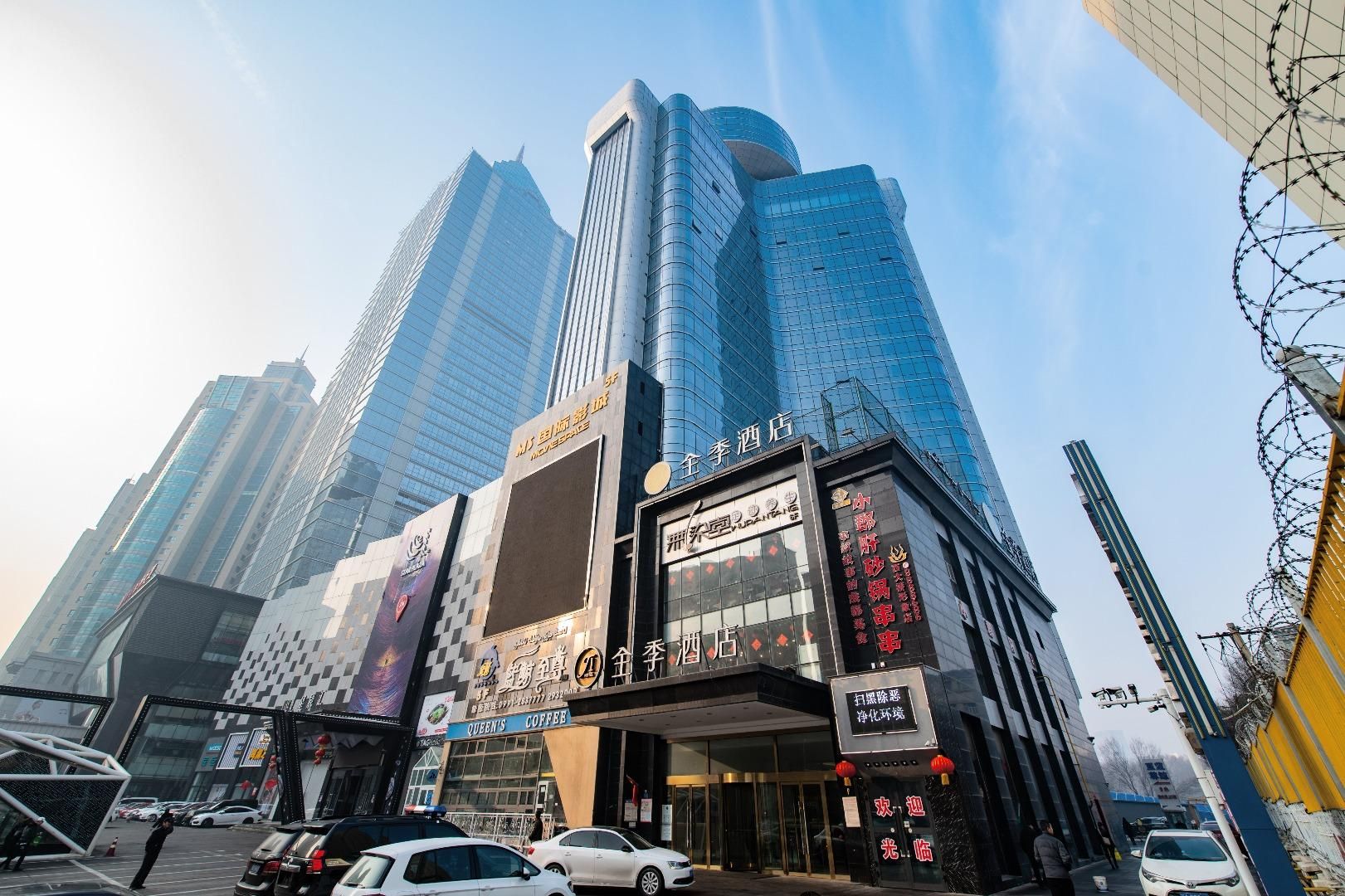 A hotel with a modern glass facade, signage for a coffee shop, and a prominent entrance.