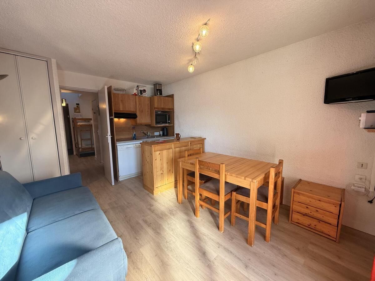 A compact living space with a kitchenette, a dining area, and a sofa.