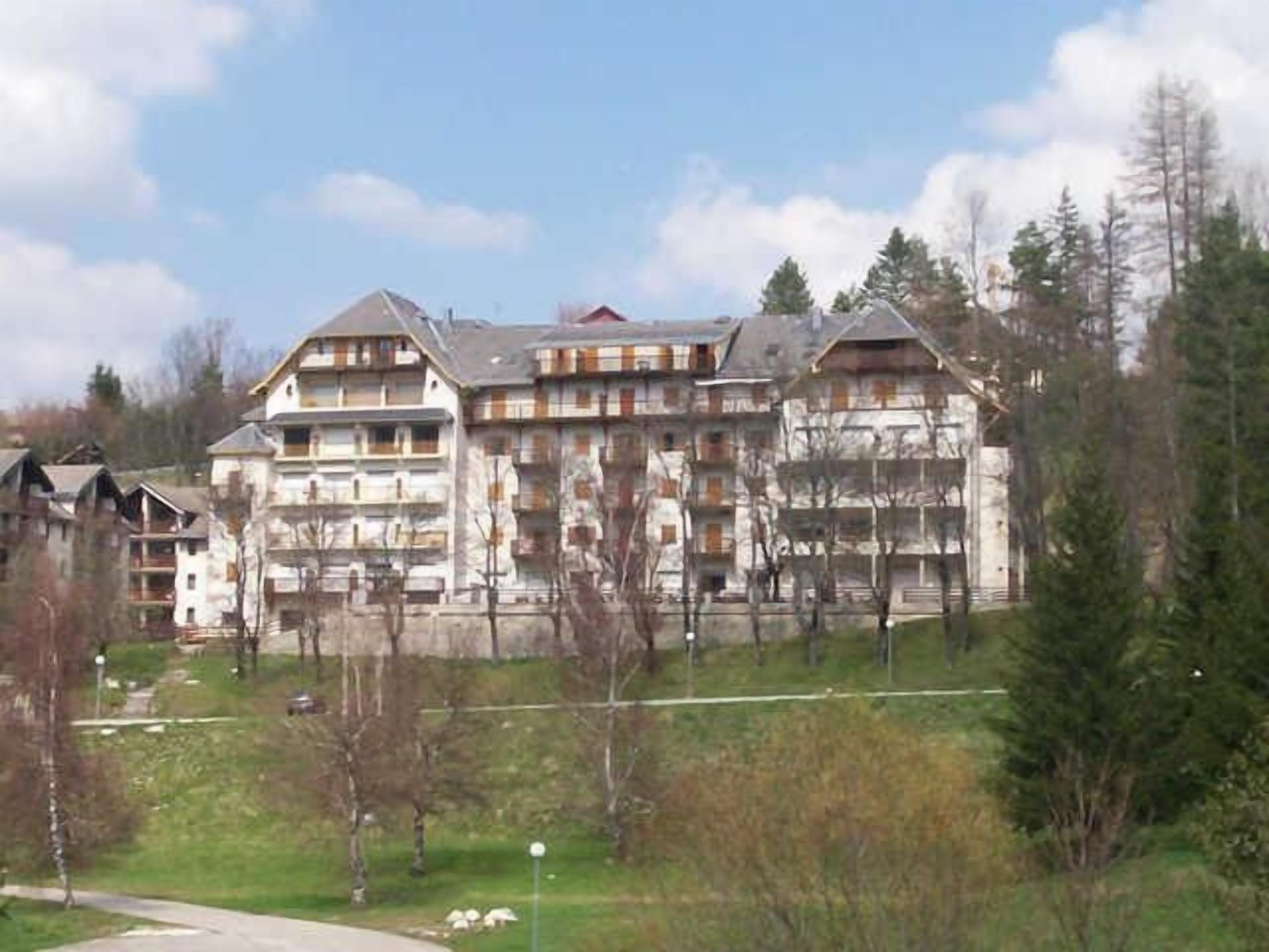 A multi-story hotel with a traditional architectural style, featuring balconies and a central courtyard.