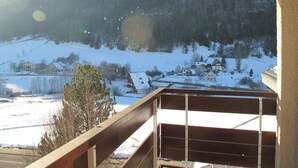 A balcony with a view of a snowy landscape and houses in the distance. - 3rd floor, view mountain, balcony, tv, 33m², Villard de Lans (Villard-de-Lans)