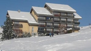 A multi-story building with balconies, likely a hotel or apartment complex, situated on a snowy slope. - 3rd floor, view mountain, balcony, tv, 33m², Villard de Lans (Villard-de-Lans)