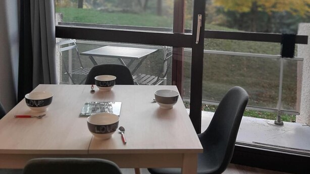 Un comedor con una mesa, sillas y tazones.