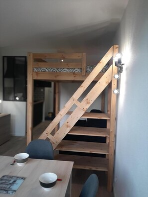 A bunk bed with a wooden ladder, a dining table with two bowls, and a chair. - 2nd floor, balcony, parking, tv, 20m², Villard de Lans (Villard-de-Lans)