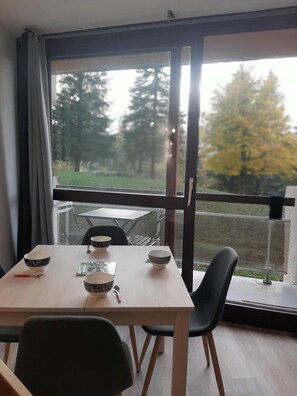 A dining area with a table, chairs, and bowls. - 2nd floor, balcony, parking, tv, 20m², Villard de Lans (Villard-de-Lans)