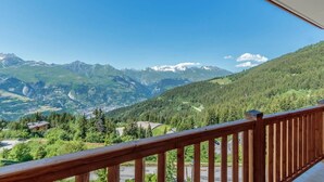 A balcony with a wooden railing overlooking a mountainous landscape with a town below. - 50m from ski slopes, 3rd floor, view panoramic, swimming pool, balcony, tv, ski locker, 46m² (Bourg-Saint-Maurice)
