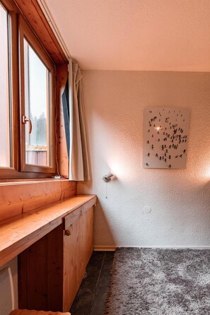 A room with a wooden bench at the window, a wall-mounted light, and a textured rug on the floor. - 7th floor, tv, 13m², Les Arcs (Les Arcs)