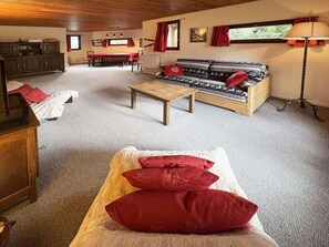 A cozy room with a sofa, a dining table, and a bed with red pillows. - Ski-in/ski-out & foot of the slopes, 3rd floor, view ski slopes, balcony, tv, 60m², Les Orres (Les Orres)