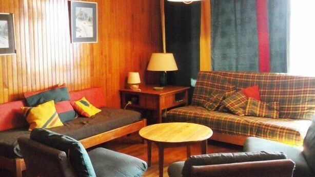A cozy living room with a sofa, armchairs, and a small table.