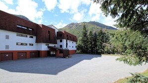 Un edificio con varias puertas de garaje, un acceso cubierto y un letrero que dice 