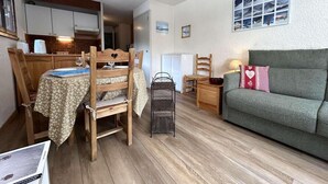 Un espacio habitable pequeño con comedor, sofá y cocina.