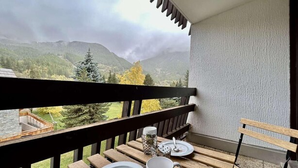 A balcony with a table set for two, overlooking a mountainous landscape. - 150m from ski slopes, 3rd floor, balcony, parking, 28m², Serre Chevalier (SERRE CHEVALIER)