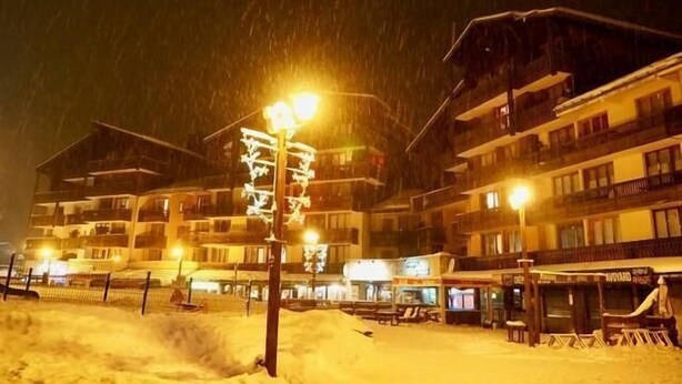 Ein mit Schnee bedecktes Hotel mit mehreren Etagen, Außenbereich und einem sichtbaren Schild.