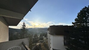 Un balcón con vistas a un paisaje montañoso y un edificio de diseño moderno.