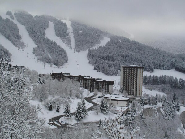 A snow-covered ski resort with a large building, possibly a hotel, and a ski lift in the background. - 5th floor, view ski slopes, balcony, parking, tv, 43m², Villard de Lans (Villard-de-Lans)