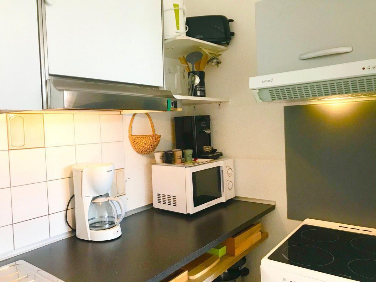 Una cocina con cafetera, microondas y estufa.