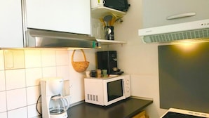 Une cuisine équipée d'une machine à café, d'un four à micro-ondes et d'une cuisinière.