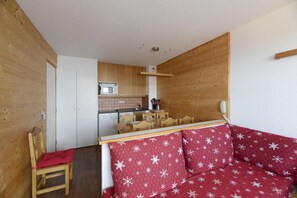 Une cuisine compacte avec des meubles en bois, un four à micro-ondes et un petit coin repas.