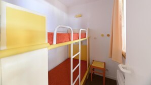 A bunk bed with a yellow headboard, a small wooden chair, and a window with curtains. - 100m from resort center, 5th floor, view ski slopes, balcony, tv, 39m², La Plagne (La Plagne)