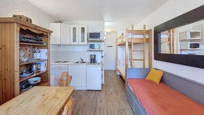Habitación pequeña con kitchenette, una litera y un comedor.